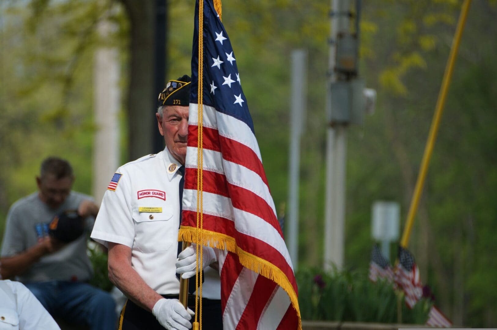 A man in uniform holding an american flag.